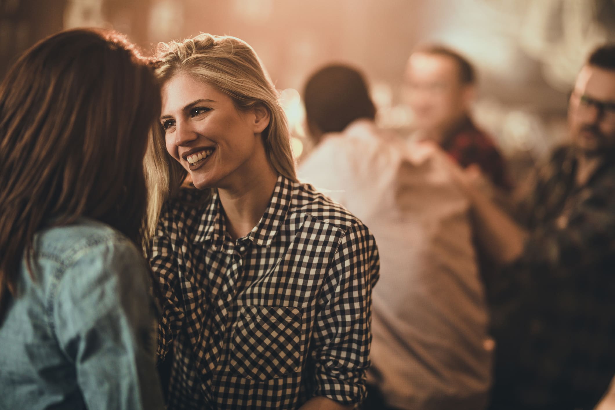 Dos chicas filtrean en una reunión de amigos.